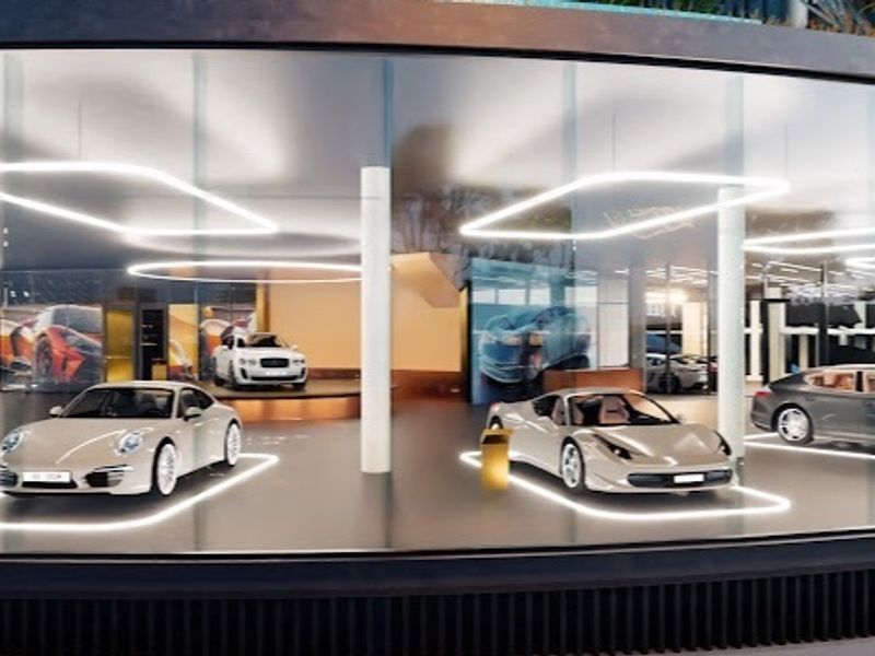 A modern, high-end luxury garage featuring extensive glass walls, structural columns, and integrated recessed LED lighting.