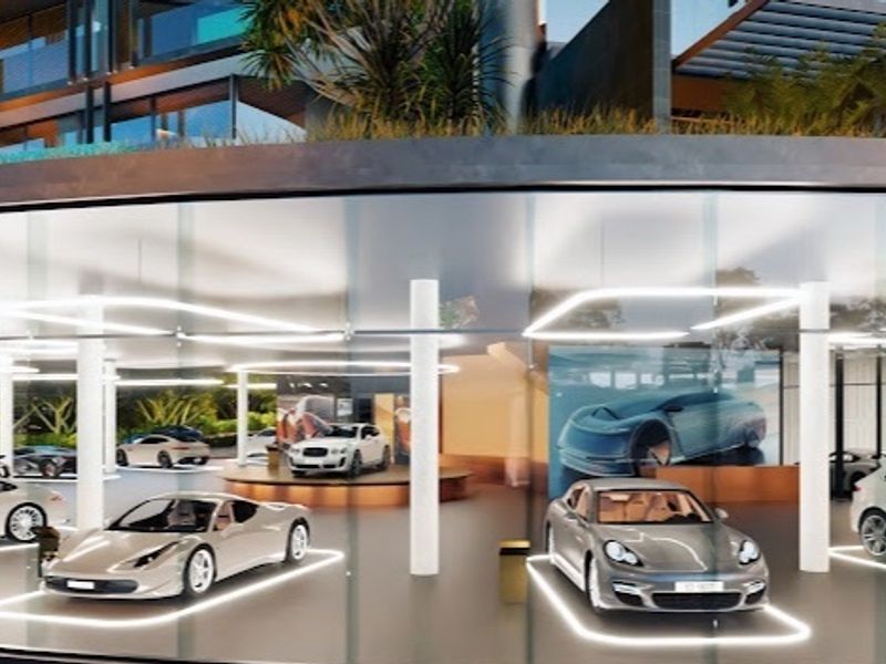 A modern, high-end luxury garage featuring a glass facade, structural columns, and integrated floor lighting, designed for premium vehicle display.