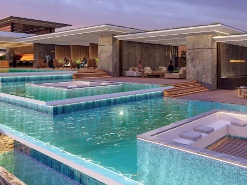 A luxurious multi-level infinity pool area featuring integrated sunken seating, stone architectural elements, and modern timber decking, perfect for high-end outdoor entertaining.