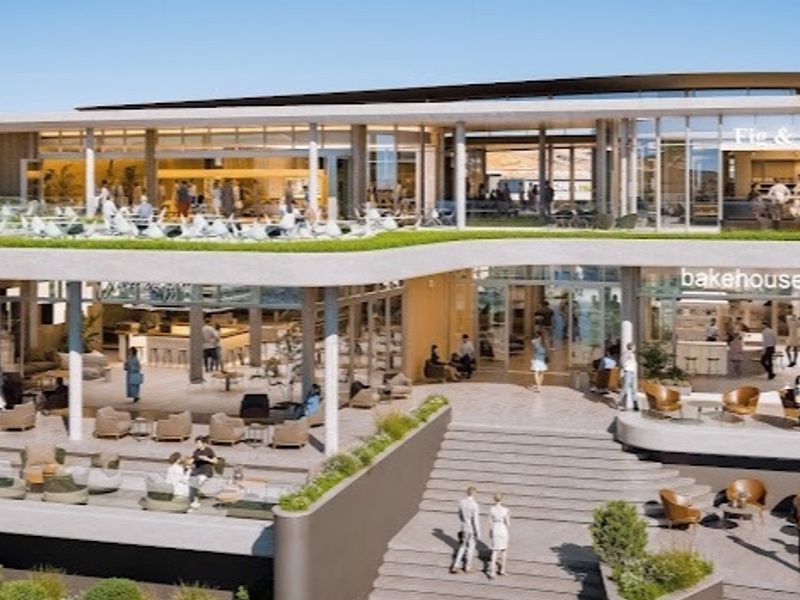 A modern multi-level commercial building featuring expansive terraces, glass balustrades, and integrated landscaped areas, designed for retail and dining accessibility.