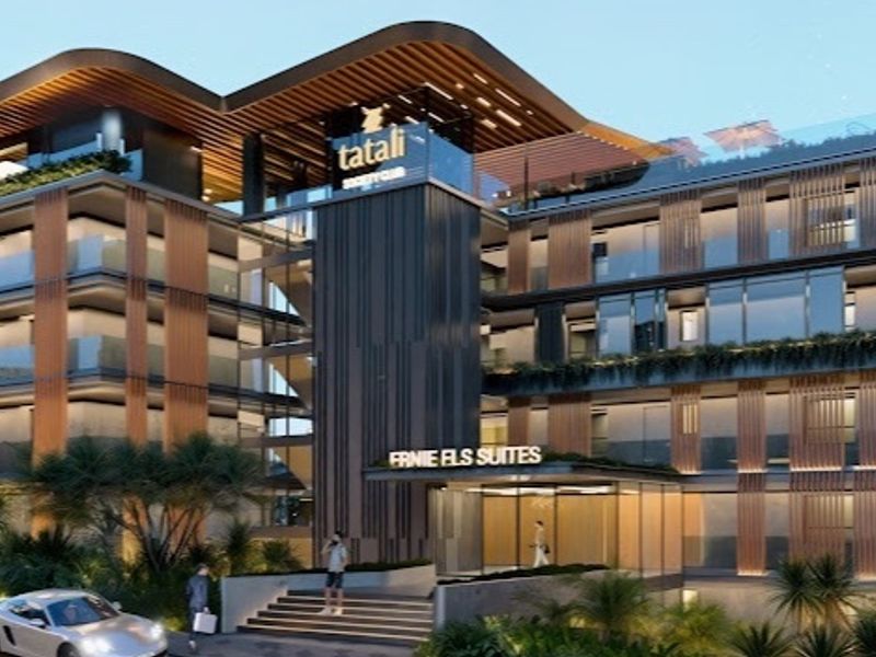 A modern apartment building exterior featuring contemporary architectural design, glass balconies, timber-look cladding, and a prominent entrance with landscaped surroundings.
