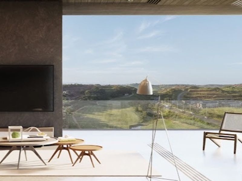 Modern open-plan living area featuring a dark feature wall and expansive floor-to-ceiling glass doors opening to a scenic landscape view.