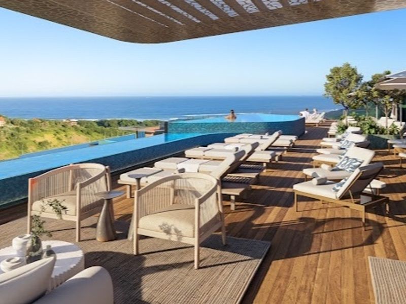 Luxury outdoor pool area featuring an infinity pool with panoramic ocean views and high-quality timber decking.