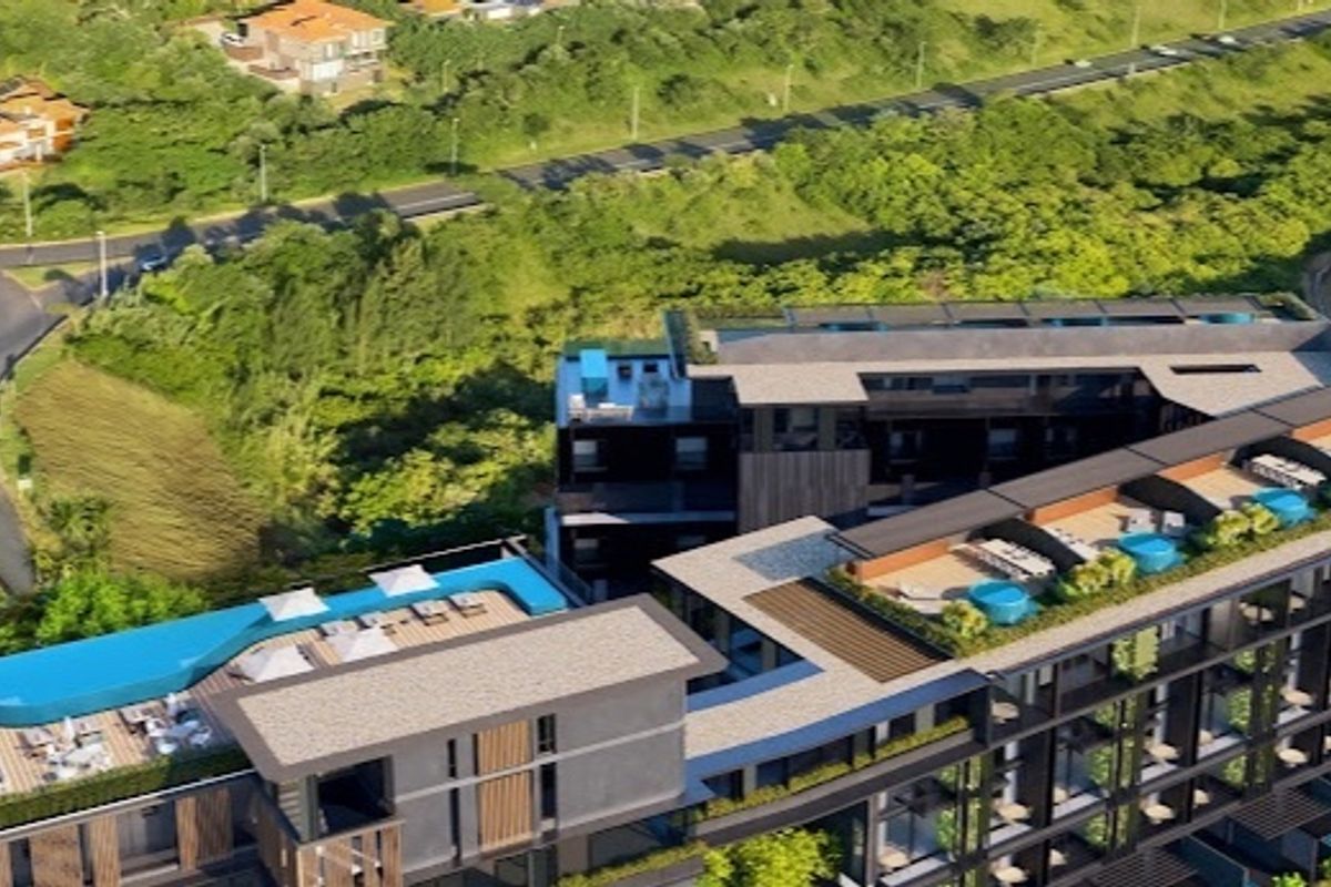 Aerial view of a modern apartment complex featuring a rooftop swimming pool, landscaped terrace areas, and contemporary architectural design.