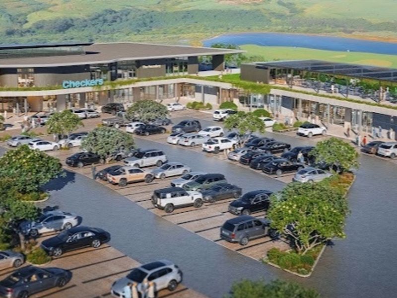 An aerial view of a modern commercial shopping center featuring extensive parking facilities and landscaped outdoor areas.