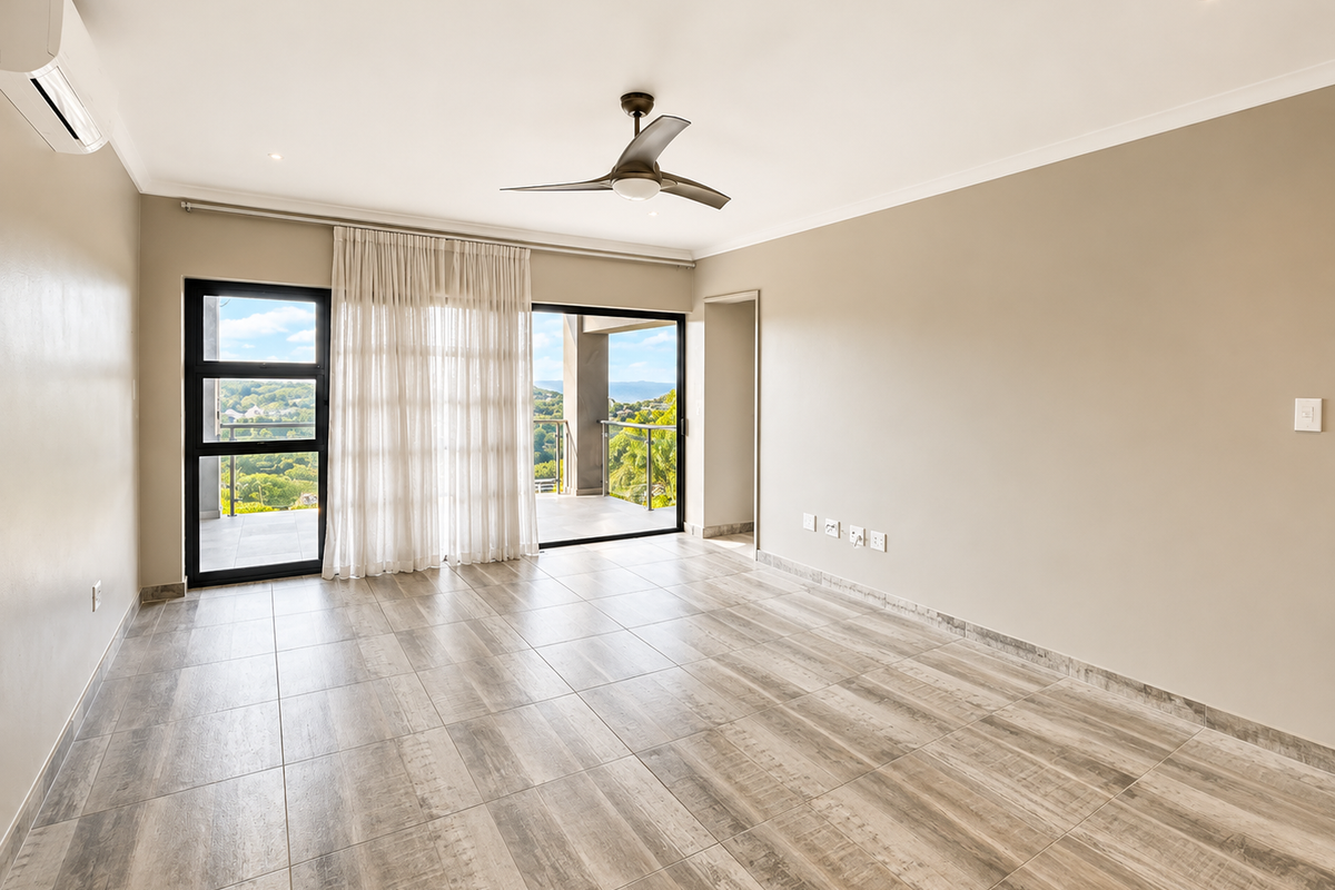 A bright, empty bedroom featuring modern wood-look tiled flooring, a ceiling fan, air conditioning, and sliding glass doors opening to a balcony with scenic views.