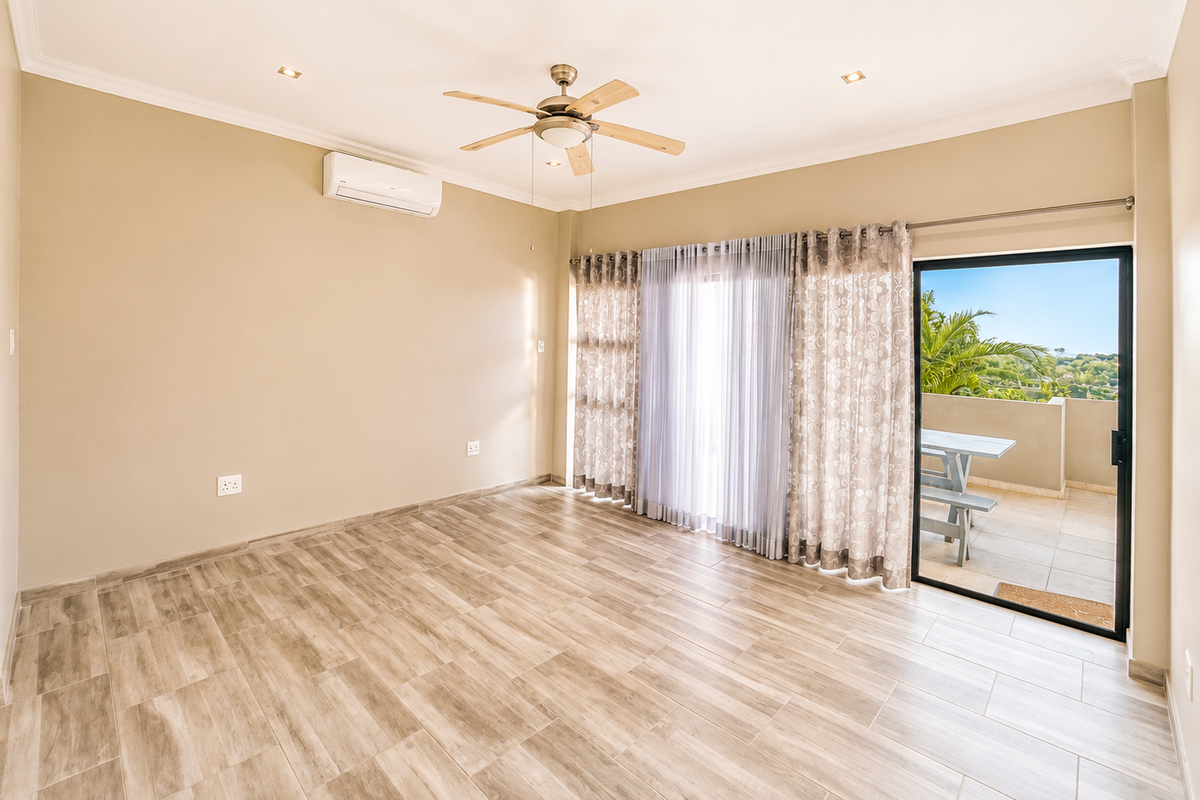 Spacious living area featuring neutral tones, wood-look tiled flooring, a ceiling fan, air conditioning, and direct access to an outdoor patio.