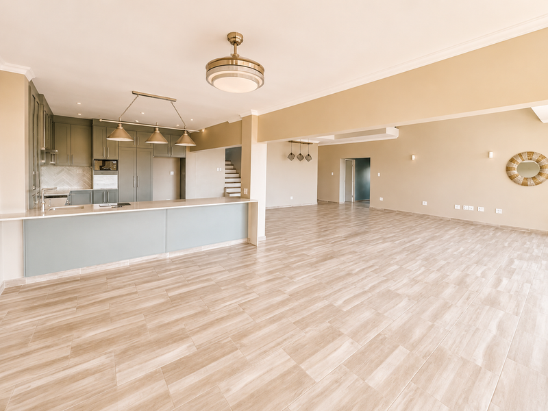 Spacious open-plan living and kitchen area featuring modern cabinetry, stone countertops, tiled flooring, and neutral finishes throughout.