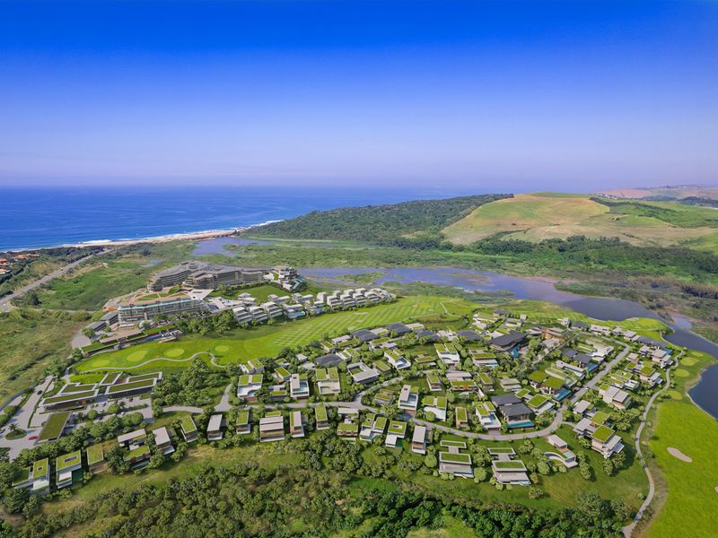 An aerial view of a master-planned residential estate featuring modern housing, integrated golf course facilities, and scenic coastal and wetland surroundings.