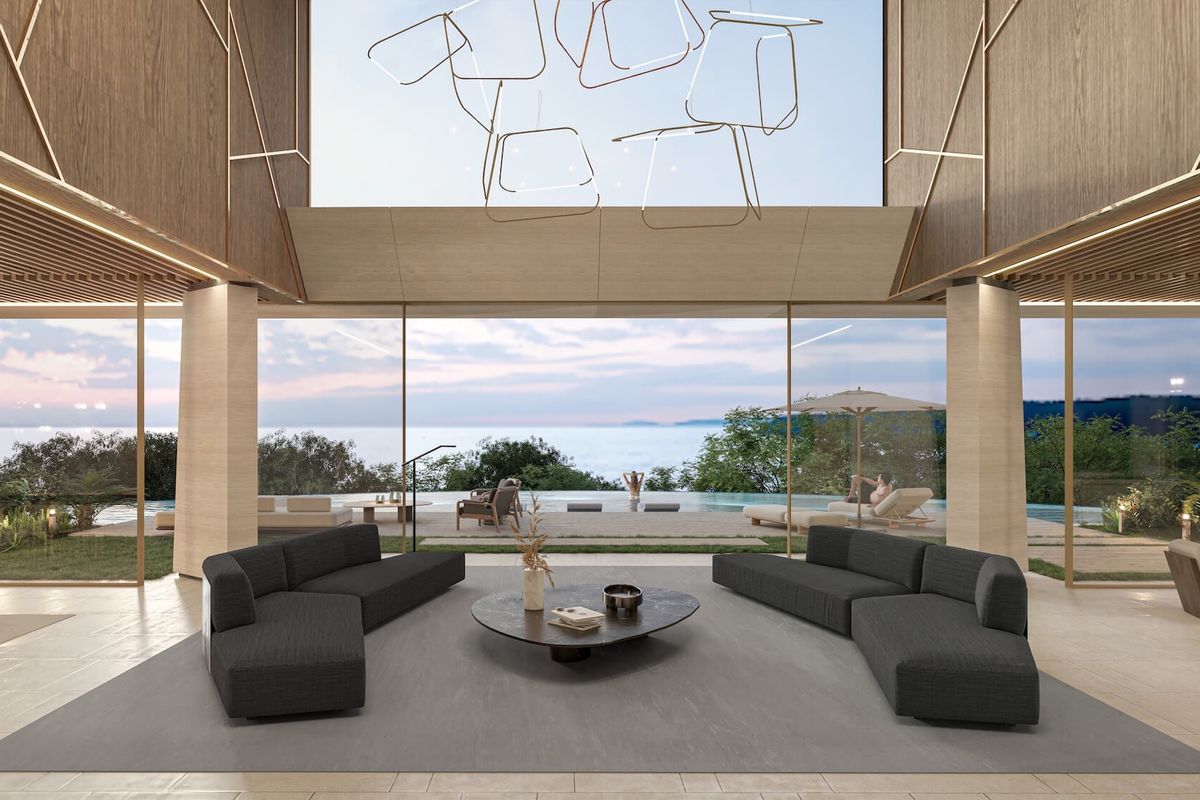 A luxurious, modern open-plan living area featuring floor-to-ceiling glass walls with expansive ocean views and high-end architectural finishes.