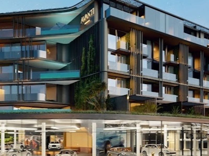 Modern multi-story penthouse building featuring contemporary architectural design, glass balconies, and integrated ground-level parking facilities.