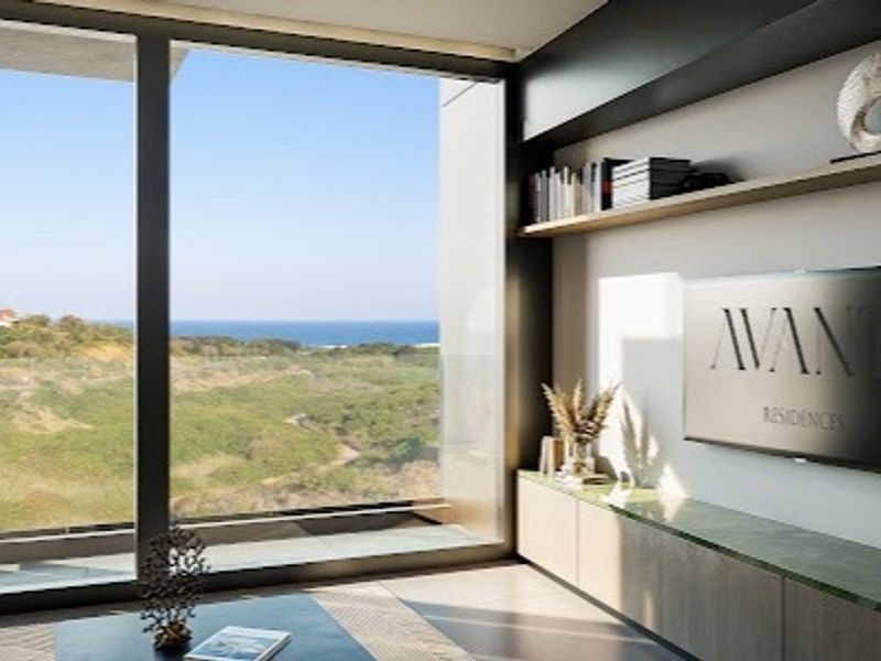 Modern living room featuring floor-to-ceiling windows with scenic coastal views, custom built-in cabinetry, and a sleek floating shelf.