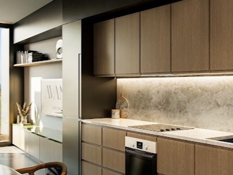 Modern kitchen featuring sleek wood-tone cabinetry, stone countertops, integrated appliances, and under-cabinet lighting, complemented by expansive windows with scenic views.