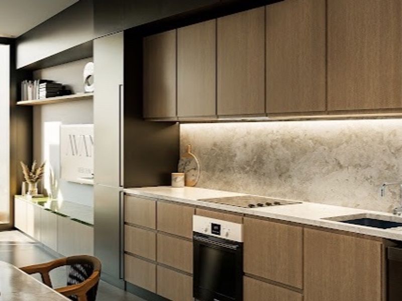 Modern kitchen featuring sleek wood-finish cabinetry, stone countertops, integrated appliances, and under-cabinet lighting, with large windows offering scenic views.