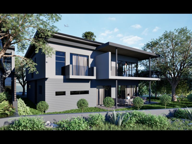 A modern two-story townhouse exterior featuring a rear balcony, covered patio, and large glass sliding doors overlooking a landscaped garden.
