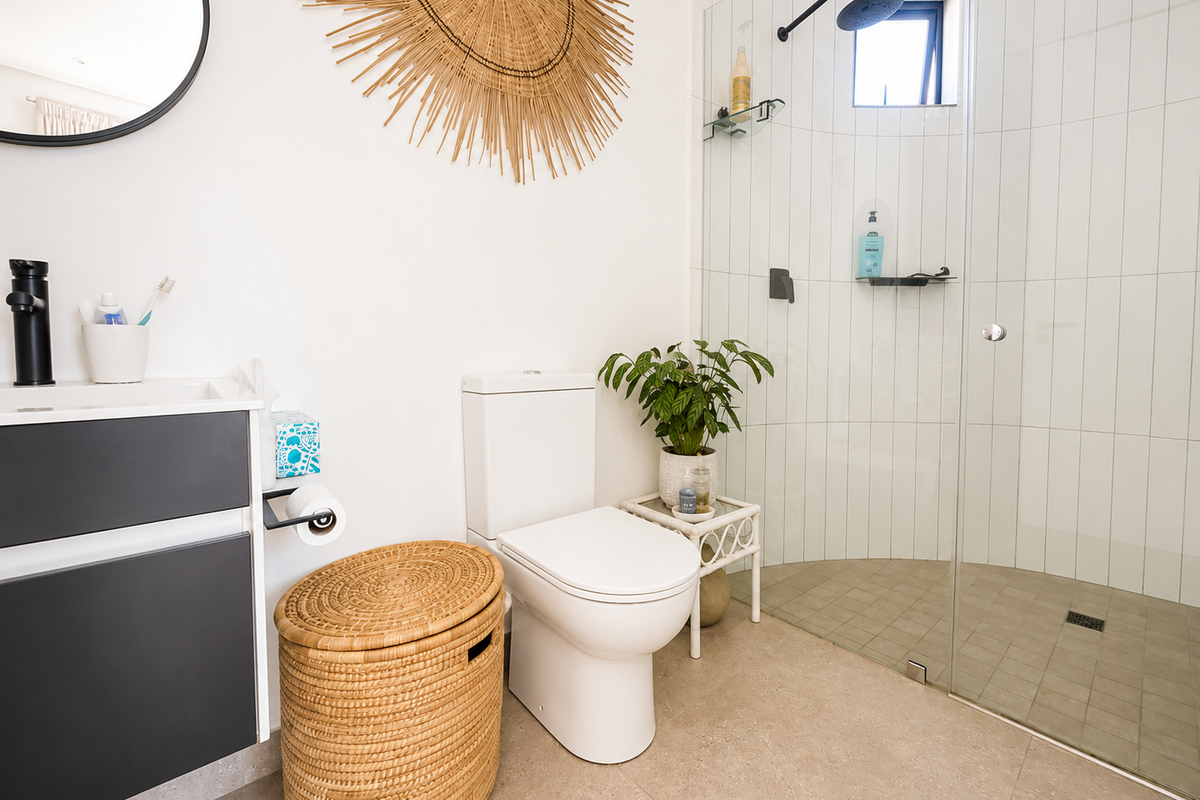 Modern bathroom featuring a sleek vanity, black tapware, a walk-in shower with glass screen, and contemporary vertical wall tiling.