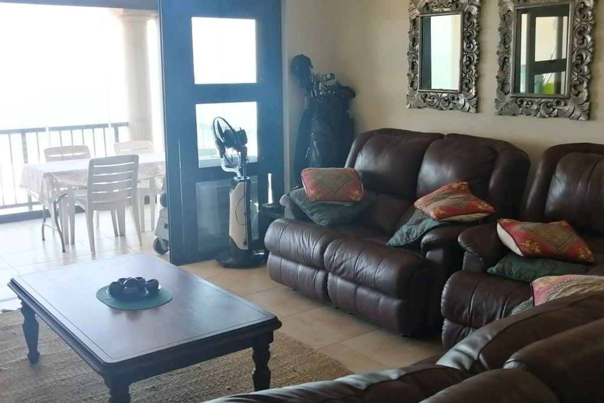 A living room area featuring tiled flooring and large sliding glass doors that provide direct access to an outdoor balcony space.