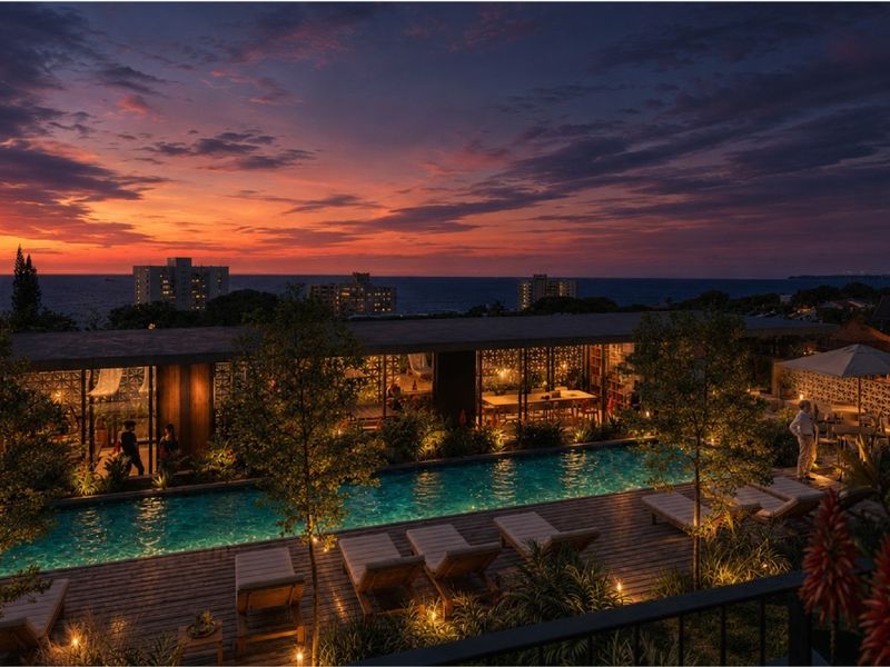 A beautifully lit outdoor pool area at sunset, featuring timber decking, decorative architectural screens, and a serene atmosphere overlooking the ocean.