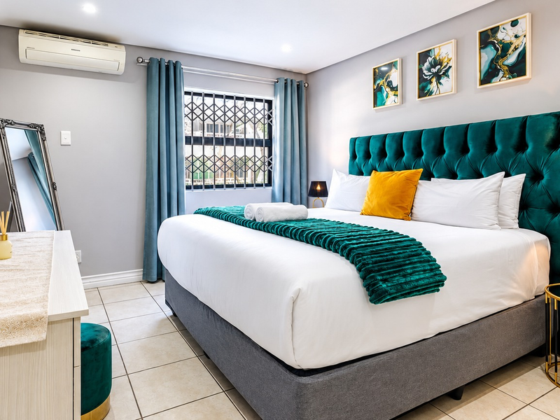 A well-maintained bedroom featuring tiled flooring, a wall-mounted air conditioning unit, and a secure window with a fitted security gate.