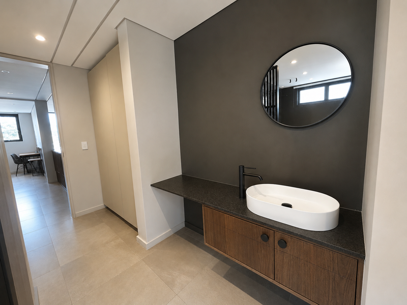 Modern bathroom featuring a floating vanity with a vessel sink, matte black fixtures, and neutral tiled flooring in a clean, contemporary design.