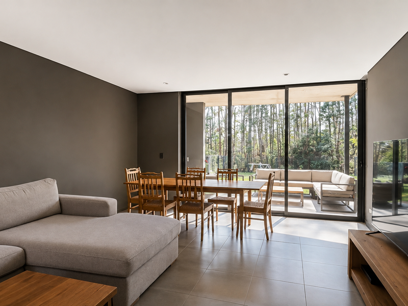 Spacious open-plan living and dining area featuring large sliding glass doors that provide seamless access to the outdoor patio and garden.
