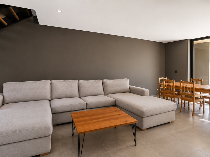 Spacious open-plan living and dining area featuring modern tiled flooring, recessed lighting, and large sliding glass doors leading to an outdoor space.
