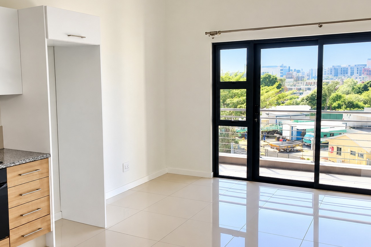 Modern open-plan kitchen and living area featuring sleek cabinetry, granite countertops, and large sliding doors opening to a balcony with urban views.