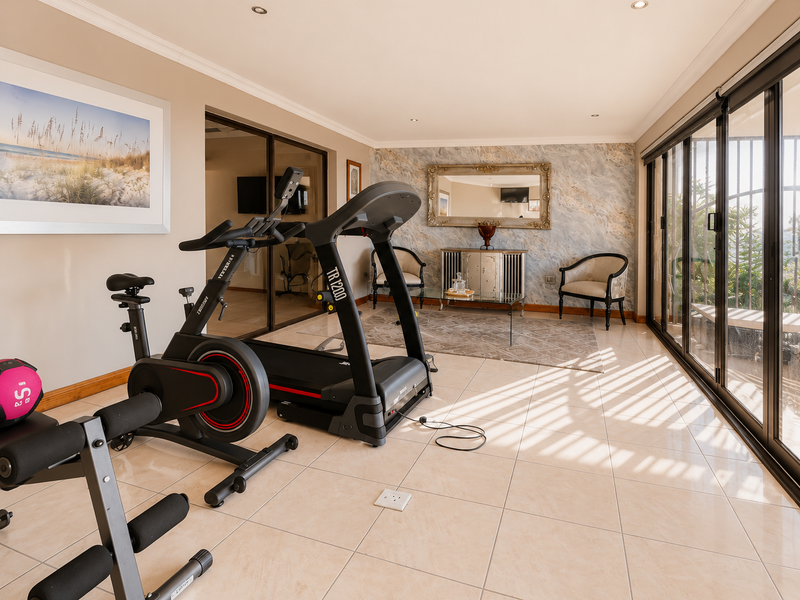 A bright and spacious home gym featuring tiled flooring, recessed lighting, and large sliding glass doors that provide ample natural light.