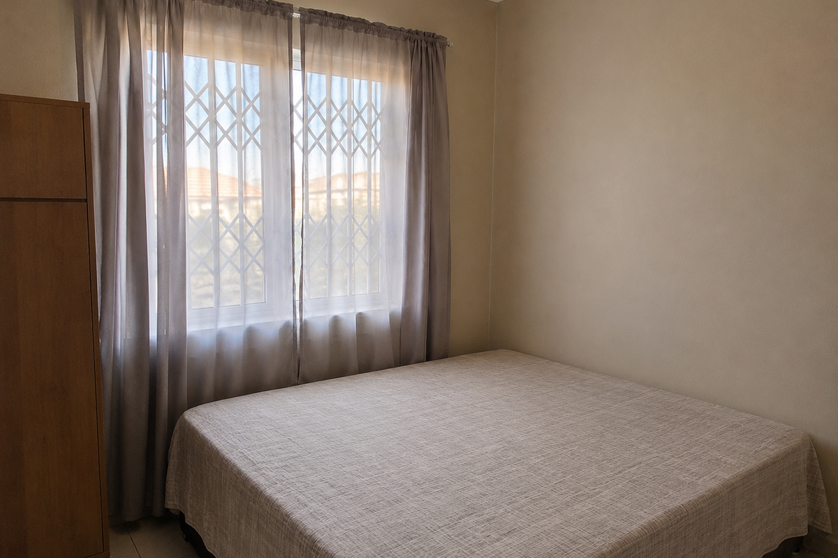 A simple bedroom featuring tiled flooring, a built-in wardrobe, and a window fitted with a security gate.