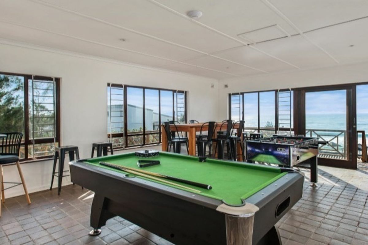 Spacious living area featuring tiled flooring, large windows, and sliding glass doors that provide ample natural light and ocean views.
