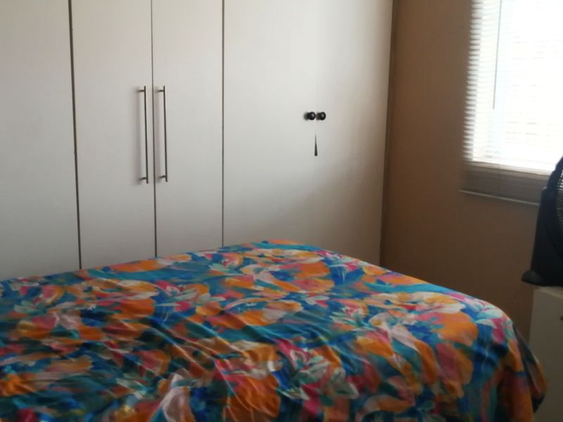 A bedroom featuring built-in cupboards and venetian blinds, providing functional storage and adjustable natural light.