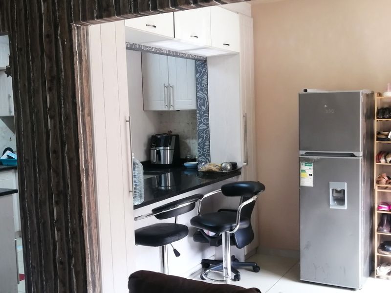 A compact kitchen area featuring built-in cabinetry, granite countertops, and a tiled backsplash, providing a functional workspace within the apartment.