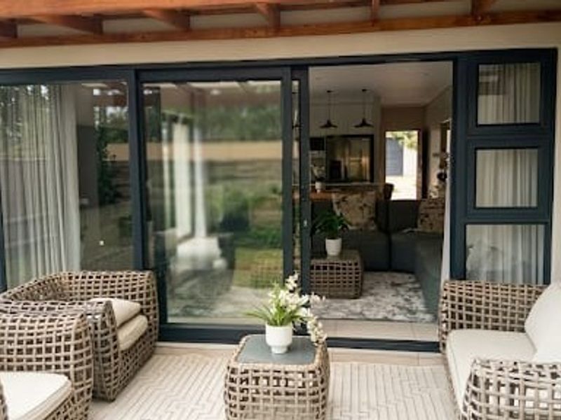 Covered patio area featuring a timber pergola, tiled flooring, and large sliding glass doors providing seamless access to the interior living space.