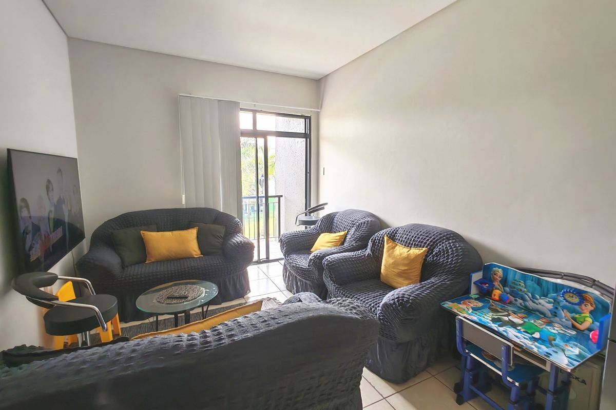 A living room area featuring tiled flooring and a sliding glass door providing access to an outdoor space.