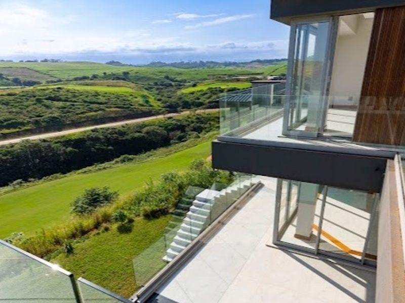 Modern multi-level balcony featuring glass balustrades and expansive views over the surrounding landscape.