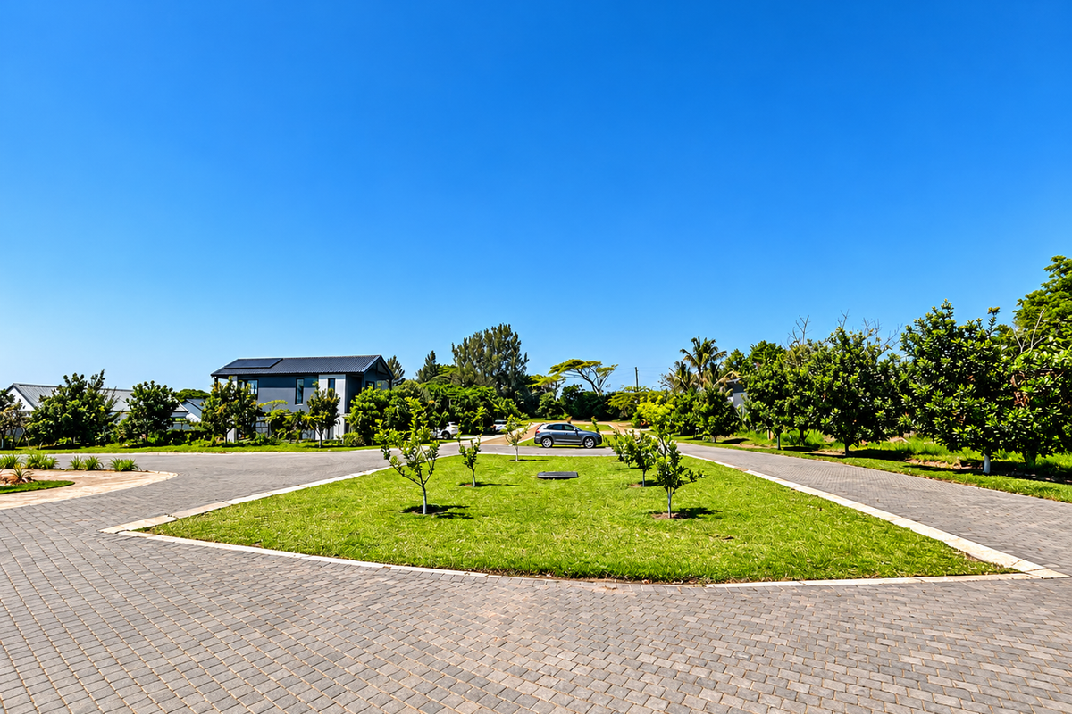 A view of the paved street and landscaped verge within a residential estate, featuring well-maintained paving and established greenery.