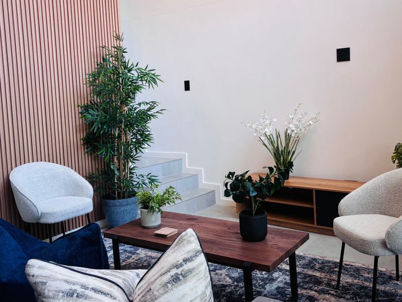 A modern living area featuring a stylish slatted timber feature wall and a staircase with tiled treads, creating a contemporary and inviting atmosphere.