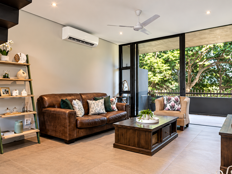Modern living room featuring tiled flooring, recessed lighting, a ceiling fan, air conditioning, and large sliding glass doors opening to a balcony.