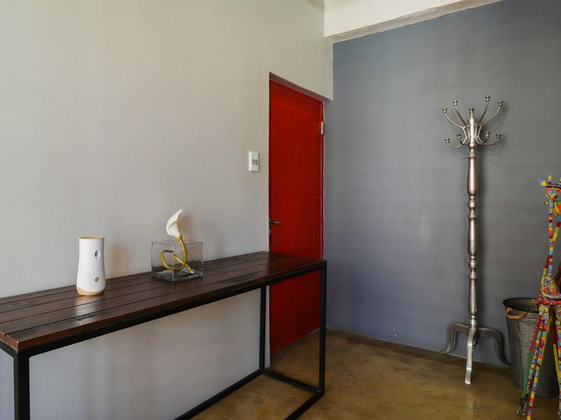 An entry area featuring polished concrete flooring and a distinctive red door, providing a modern industrial aesthetic to the home's entrance.