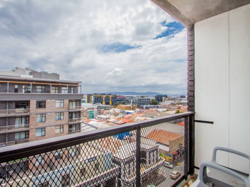 A private balcony featuring a metal mesh balustrade and offering expansive urban views over the surrounding neighbourhood.