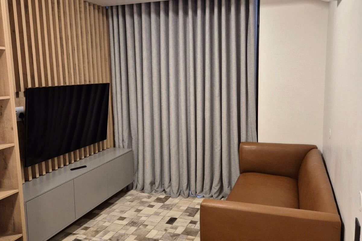 A modern living room featuring a timber slat feature wall, built-in cabinetry, and a split system air conditioner.