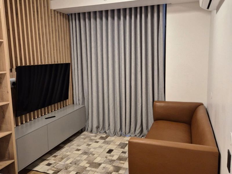A modern living room featuring a timber slat feature wall, built-in cabinetry, and a split system air conditioner.