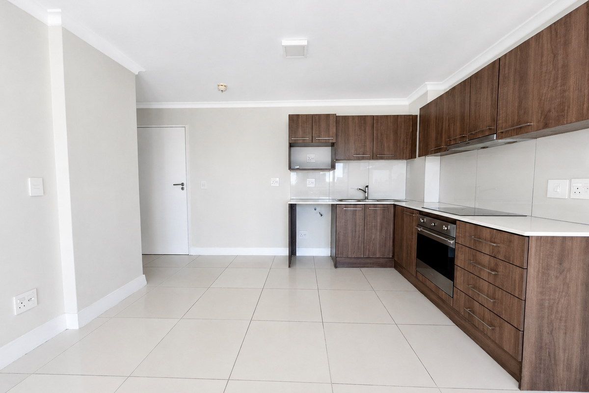 Modern kitchen featuring dark wood cabinetry, stone countertops, integrated oven, electric hob, and tiled flooring in a clean, open-plan layout.
