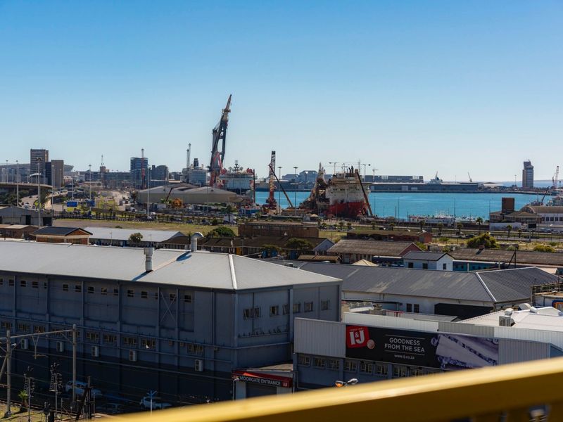 An elevated urban view overlooking the industrial harbour area, shipping docks, and surrounding city infrastructure.