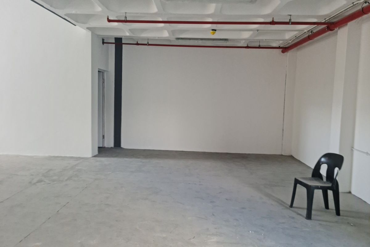 An open-plan industrial utility space featuring an exposed waffle slab ceiling, fire sprinkler system, and durable concrete flooring.