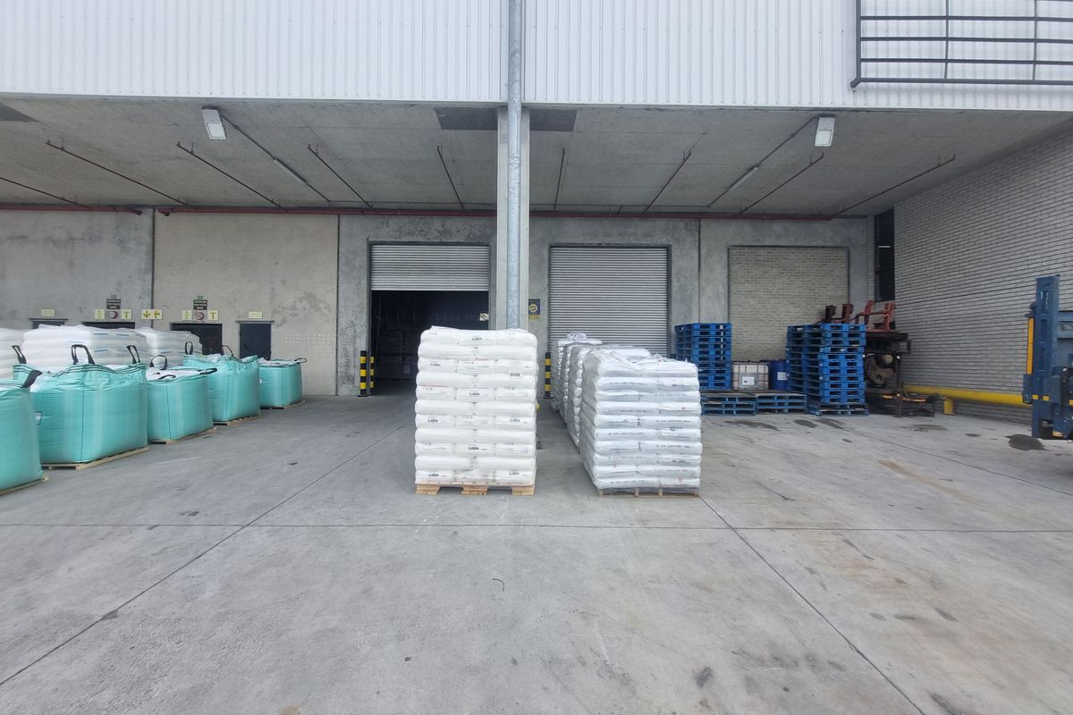 Industrial loading bay area featuring concrete flooring, roller shutter doors, and covered loading access for efficient logistics and warehouse operations.
