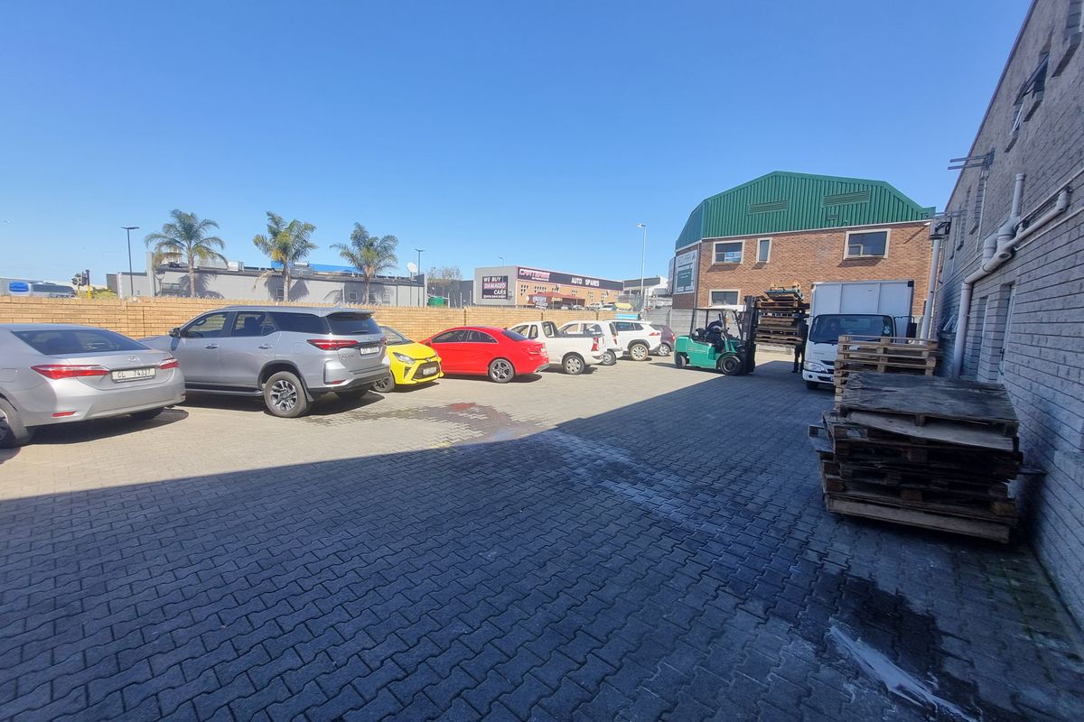 Exterior view of an industrial property featuring a paved yard area used for parking and loading operations.