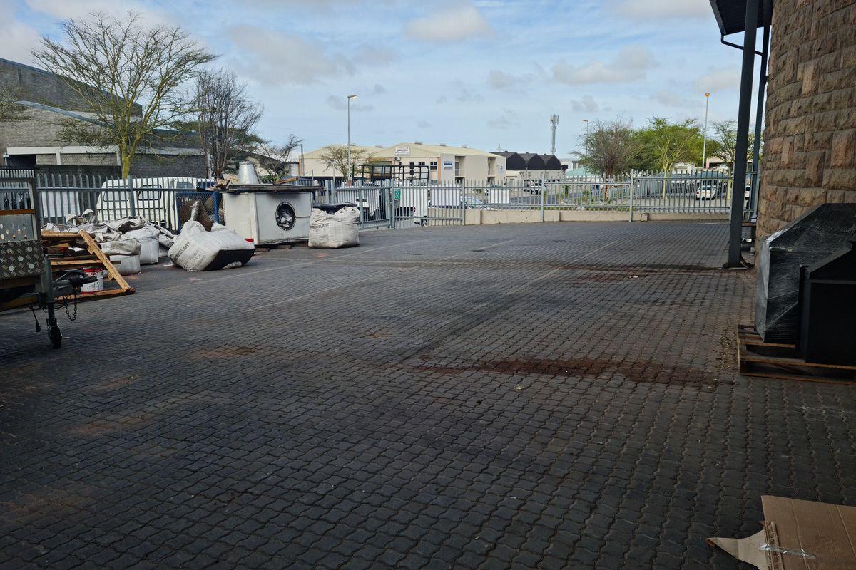 An industrial exterior yard area featuring paved surfacing, enclosed by perimeter fencing, suitable for storage or operational use.