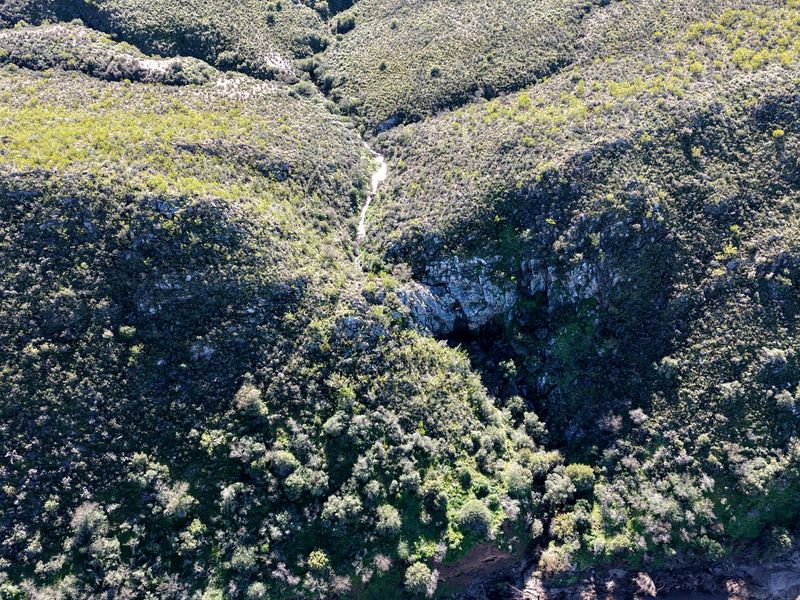 An aerial view of the farm property showcasing the natural landscape, rugged rock formations, and native vegetation.
