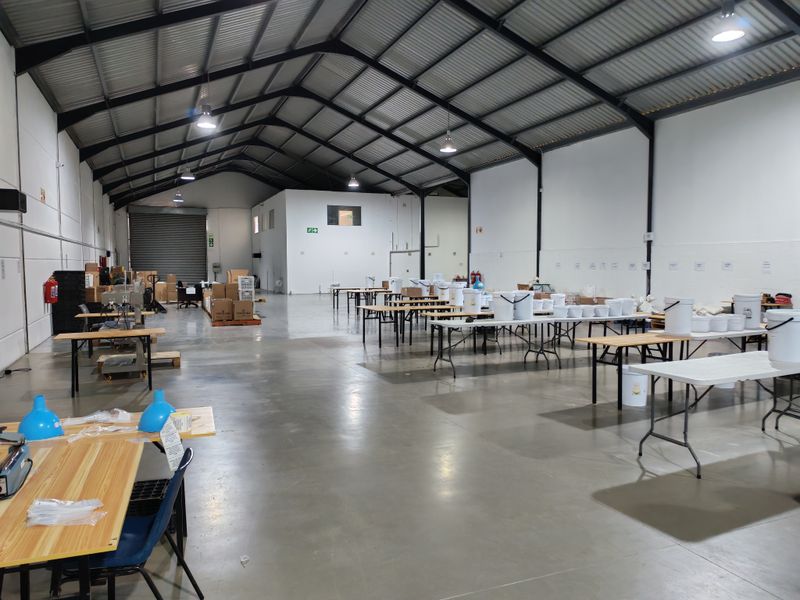Spacious industrial warehouse featuring high-bay lighting, exposed steel roof trusses, and durable polished concrete flooring, suitable for various commercial or storage operations.